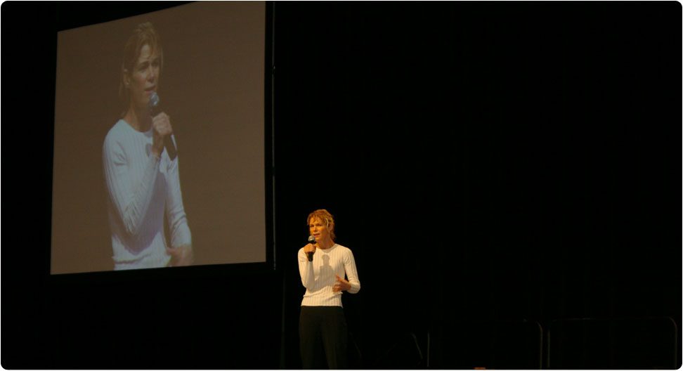 Woman in white speaking in a forum